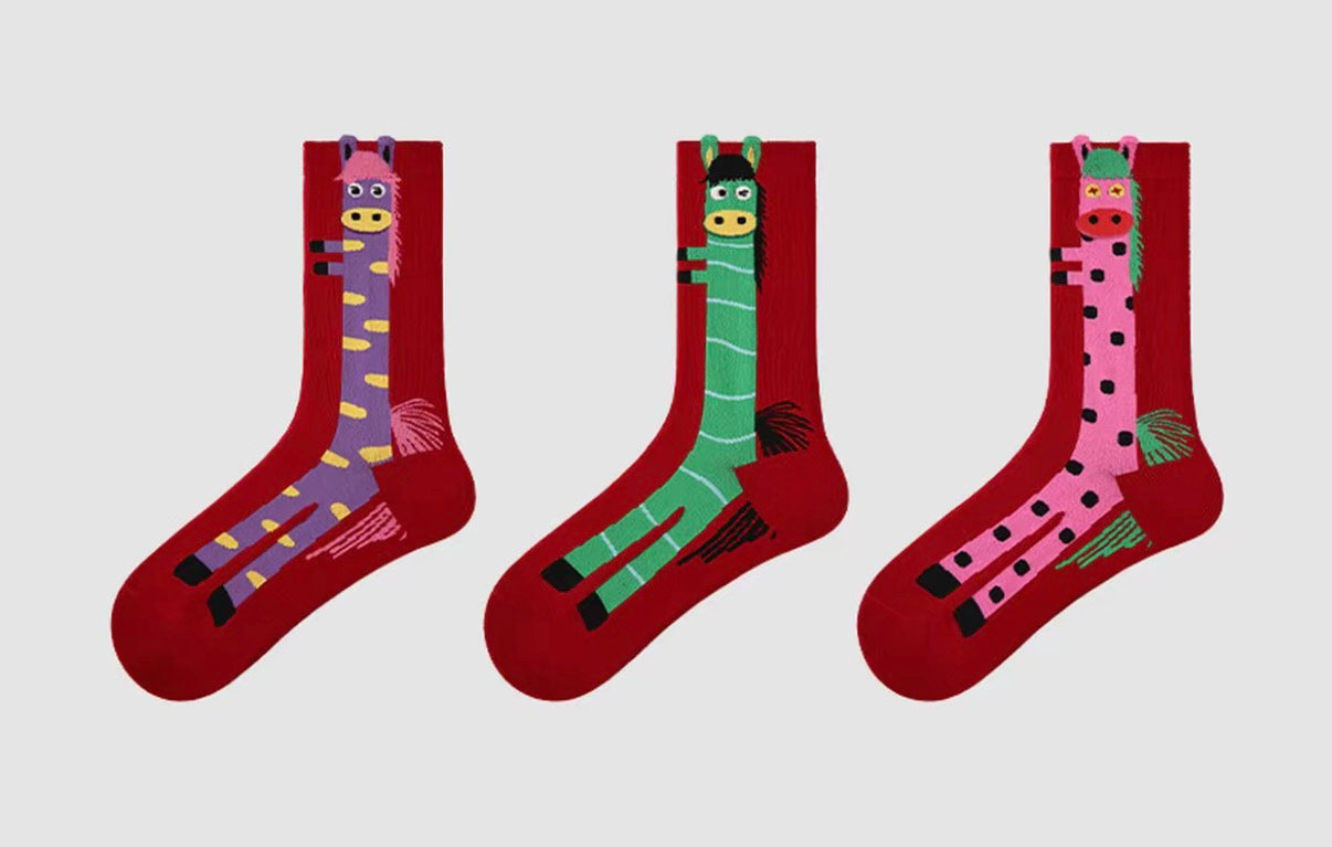 Year of Horse socks pack featuring three red socks with playful horse designs in purple, green, and pink